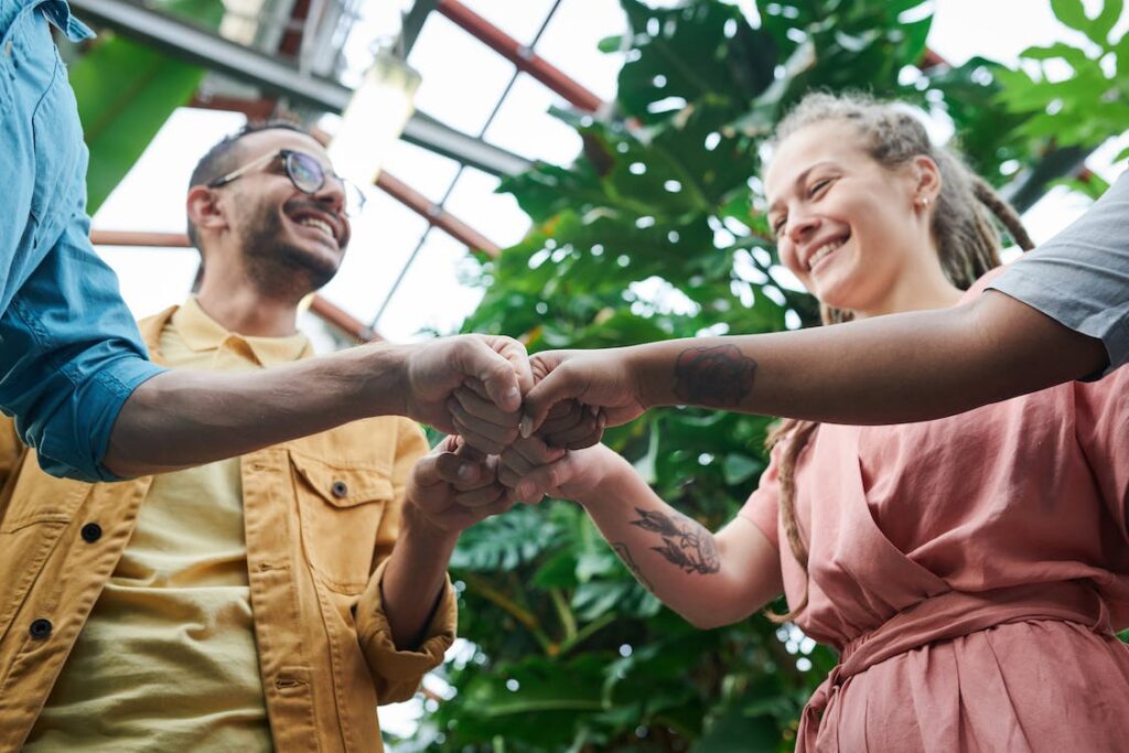 Menschen, die Hände in der Mitte zu einem Fistbump zusammenführen