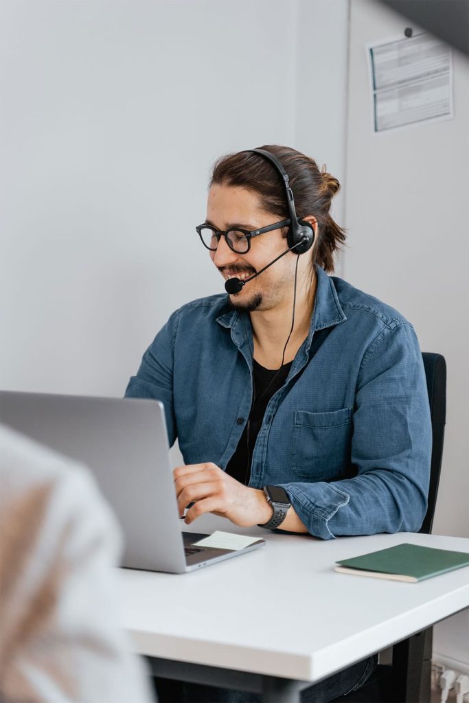 Mann am Laptop der telefoniert