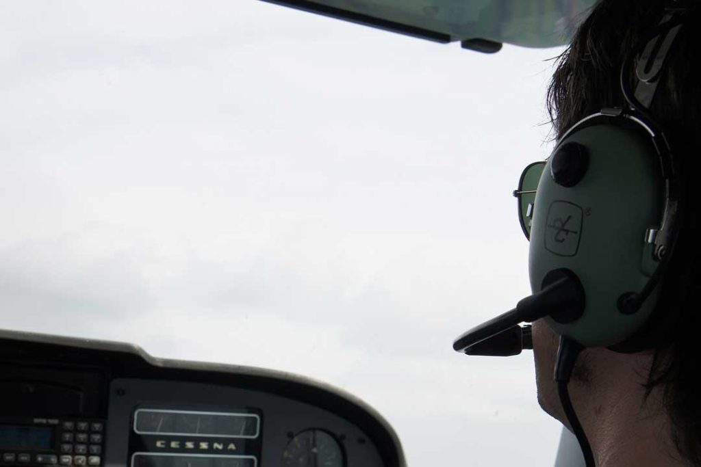Das Bild zeigt einen Copiloten, welche in einer Cessna am Steuer sitzt.