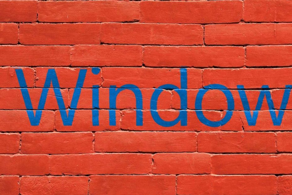 Das Bild zeigt eine rote Backsteinwand mit dem Logo von Windows 10.